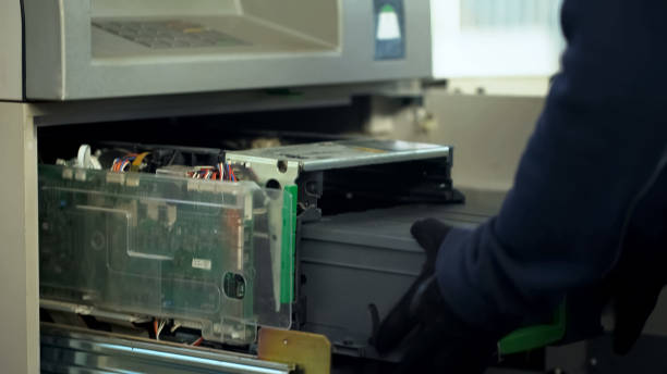 istock Maintenance worker inserting cases with cash in ATM, authorized access, service 1072205376