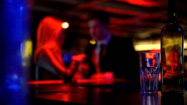 istock Couple first dating in nightclub, both drinking beverages, blurred background 1072206974