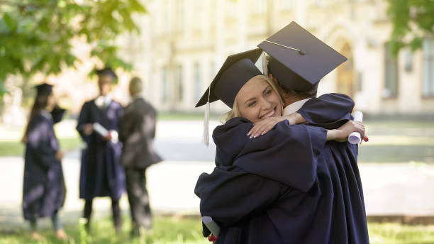 istock College graduates having conversation, hugging each other, university friendship 1072207482