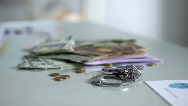istock Handcuffs and money on table, bribery punishment, financial control system 1072208456