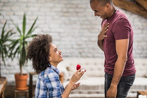 Feliz mujer afroamericana propone a su novio en casa. photo