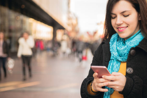 istock Young woman using phone on a city street 1072220430