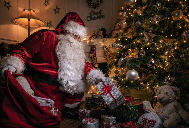istock Santa Claus insert gifts under the christmas tree 1072221236