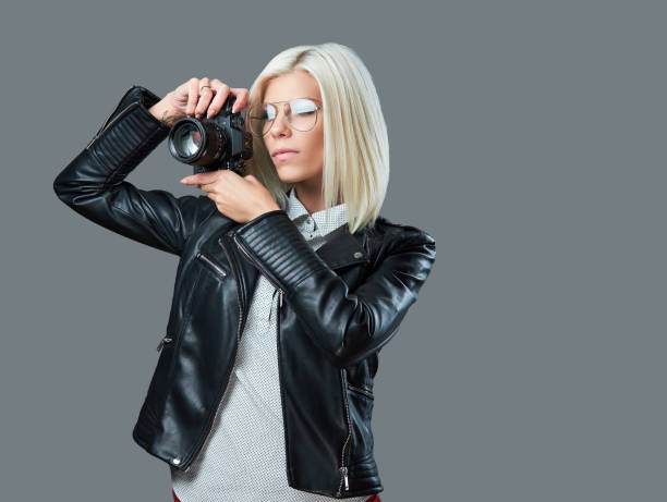 istock A blond female taking pictures with professional digital camera. 1072223226