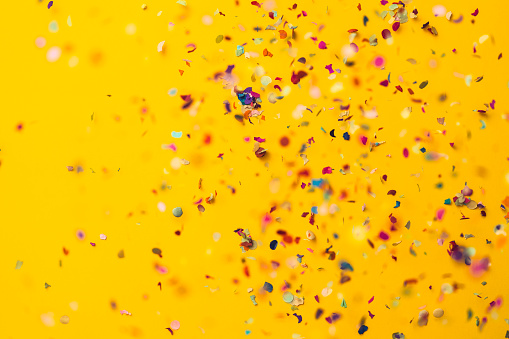 Lluvia de confeti sobre fondo amarillo photo
