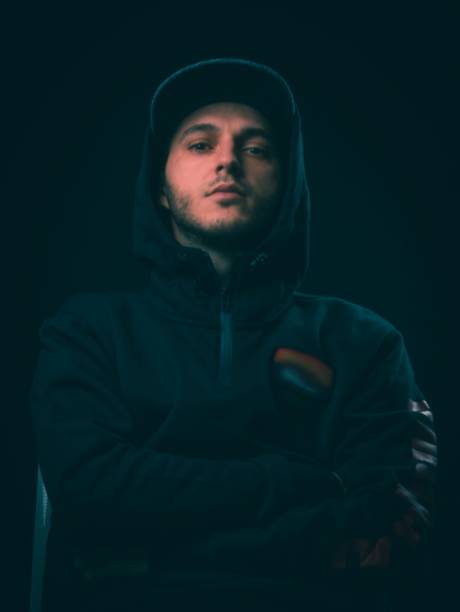 istock young man with black hoodie posing on a black background. Studio shot. 1072230754