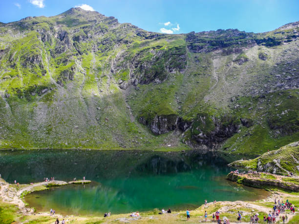 The Transfagarasan road. Transfagarasan road, Romania, - August 3, 2017: Tourists near the dam and lake Balea. balea lake romania stock pictures, royalty-free photos & images
