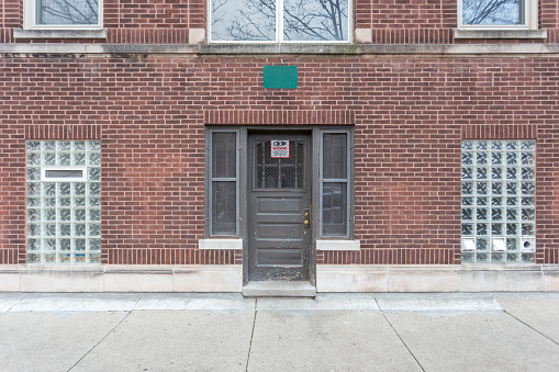 Red brick building with door and fogged out windows