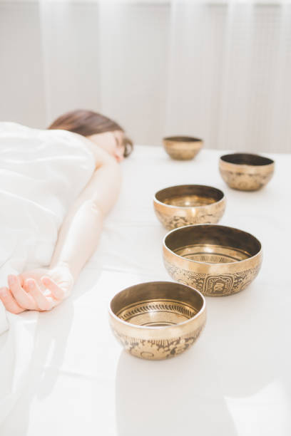istock Girl doing massage therapy singing bowls in the Spa 1072236308