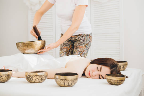 istock Girl doing massage therapy singing bowls in the Spa 1072236348