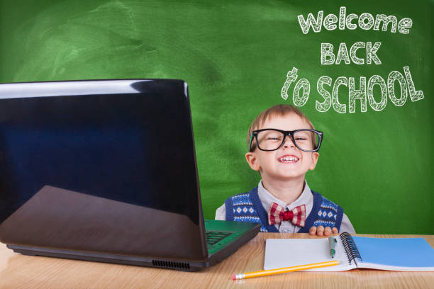 istock Child with laptop peeking in the classroom 1072236470