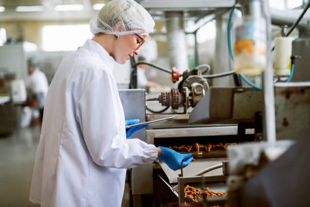 istock Female worker using tablet for controling products while standing in food factory. 1072244442