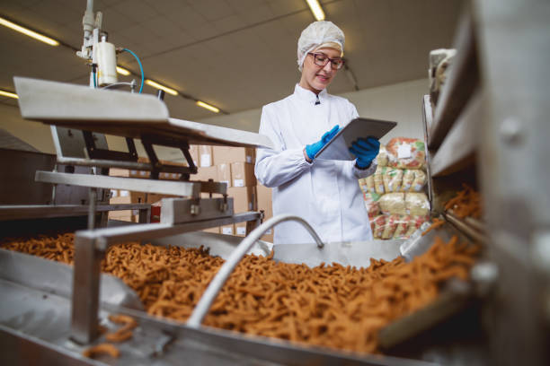 istock Female worker using tablet for controling products while standing in food factory. 1072244476