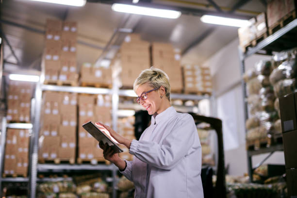 istock Happy Caucasian factory worker using tablet while standing in warehouse. 1072246722
