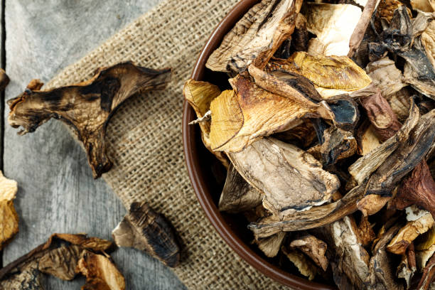 istock dried mushrooms on a wooden background on burlap. 1072248180