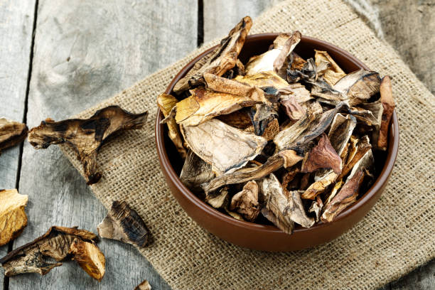 istock dried mushrooms on a wooden background on burlap. 1072249392