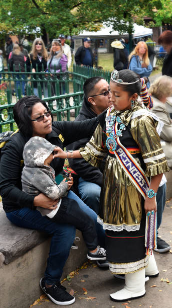 Native American dancers Santa Fe, New Mexico:  A member of a traditional Native-American dance group from Zuni Pueblo in New Mexico talks with family members after performing in Santa Fe, New Mexico, on Indigenous Peoples Day, also known as Columbus Day. anasazi stock pictures, royalty-free photos & images