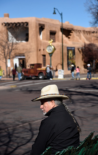 Santa Fe, New Mexico: An Hispanic man (Ramon Jose Lopez) sits on a bench in the historic Plaza in Santa Fe, New Mexico.