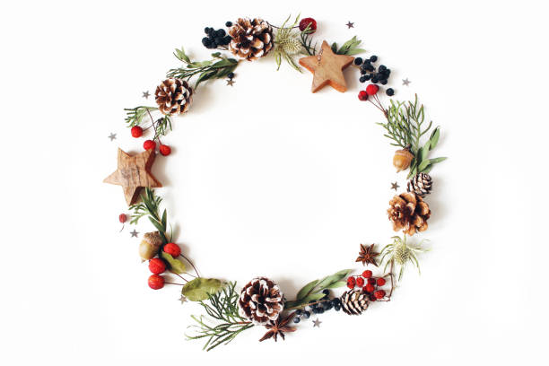 Christmas circle floral composition. Wreath of cypress, eucalyptus branches, pine cones, rowan berries, anise, confetti stars and sea holly flowers on white background. Winter wedding design. Flat lay Christmas circle floral composition. Wreath of cypress, eucalyptus branches, pine cones, rowan berries, anise, confetti stars and sea holly flowers on white background, winter wedding design. Flat lay eucalyptus tree photos stock pictures, royalty-free photos & images