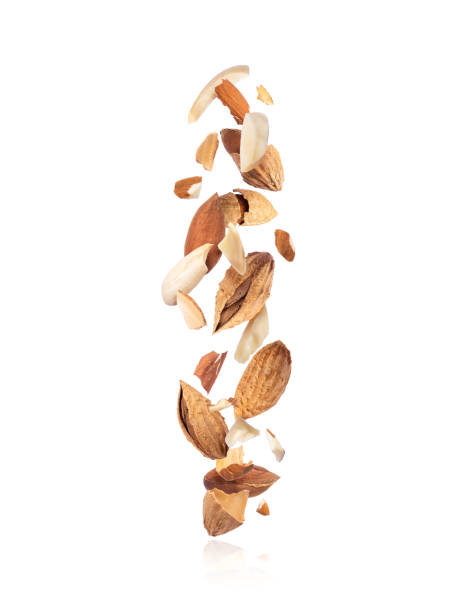 Cracked almonds fall down isolated on white background Cracked almonds fall down isolated on white background almond slivers stock pictures, royalty-free photos & images