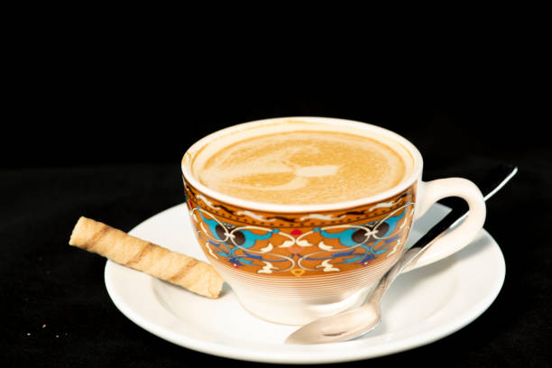 Delicious vanilla latte coffee with wafer rolls with isolated black background