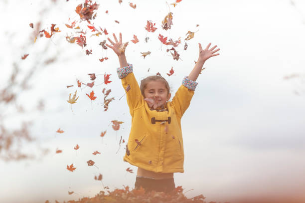 istock Girl playing in leaf pile 1072254436