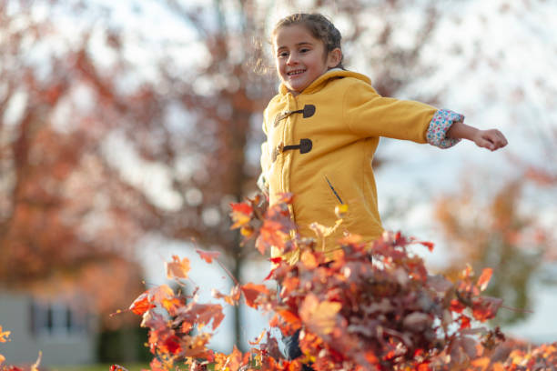istock Girl jumping in fallen leaves 1072254458