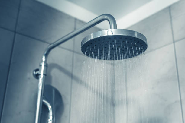 istock Water running from the shower head in the bathroom. Blue toned image 1072255008