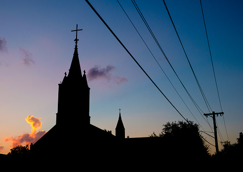 Christian church and power lines in silhouette in New Braunfels, Texas.