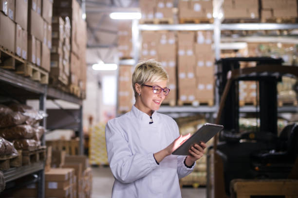 istock Happy Caucasian factory worker using tablet while standing in warehouse. 1072261886