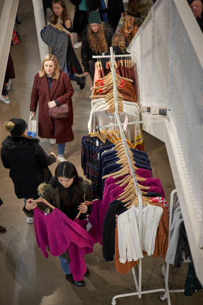 persone che fanno shopping in un negozio di abbigliamento di design nel centro di londra durante il black friday. - shopping mall foto e immagini stock