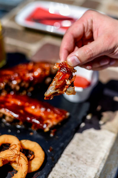 istock Young man eating delicious roasted ribs in restaurant 1072270732