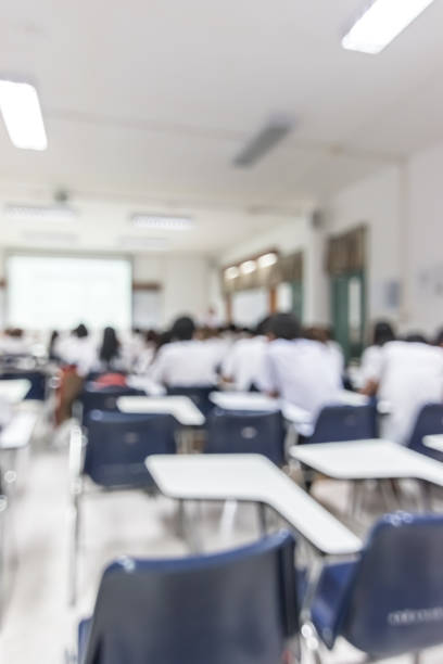 istock Blur school background back view university students writing answer doing exam in classroom 1072286920