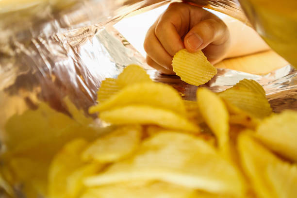 istock Hand hold potato chips inside snack foil bag 1072287070