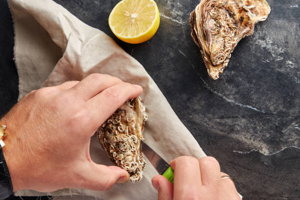 ostras frescas do homem abertura - prepared oysters prepared shellfish shucked seafood - fotografias e filmes do acervo