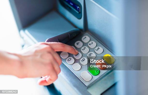A Person Withdrawing Money From A Atm Machine Stock Photo - Download Image Now - ATM, PIN Entry, Paper Currency