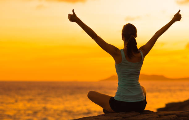 mujer sana celebrando durante una hermosa puesta de sol. felices y libres. - beach sea zen like nature fotografías e imágenes de stock