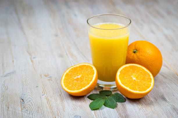 istock Orange juice and citrus fruits on rustic wooden table with copy space 1072299312