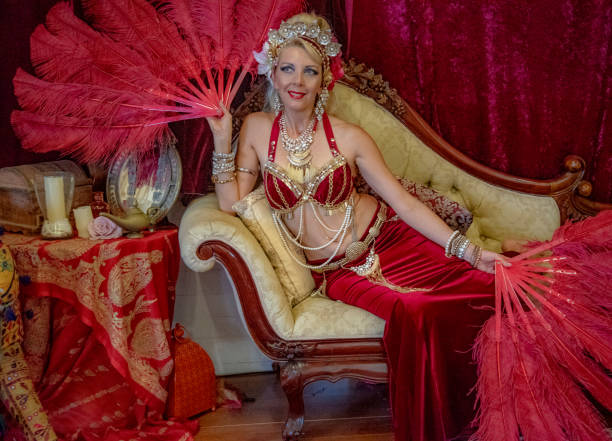 istock Belly dancer rests with red fans on Chaise Lounge. 1072299348