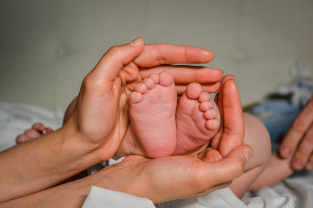 istock Baby's legs in mother's arms. 1072299768