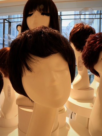 Group of Asian female mannequin heads wearing wigs.