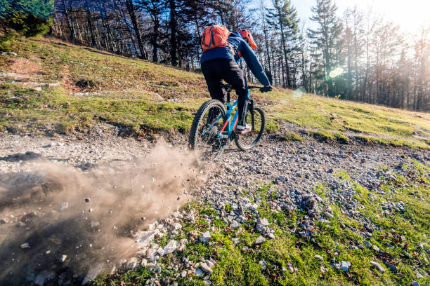 istock Mountain biker going down hill on a gravel footpath 1072309462