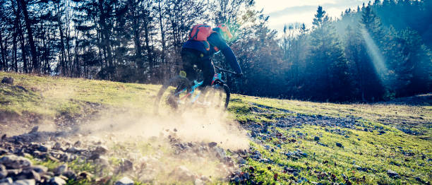 istock Mountain biker riding fast downhill on a forest meadow 1072309464