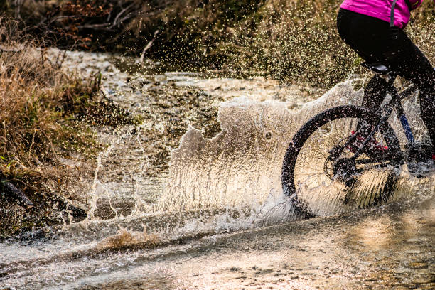 istock Splashing water trail behind a mountain biker 1072309506