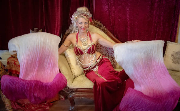 istock Belly dancer rests with silk fans on Chaise Lounge. 1072313444