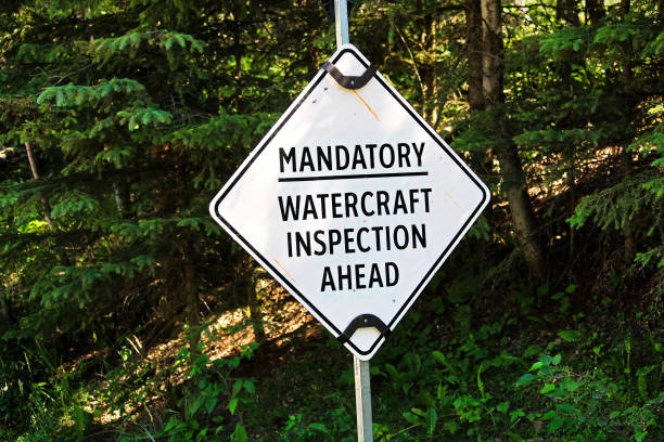 A white mandatory watercraft inspection ahead sign.