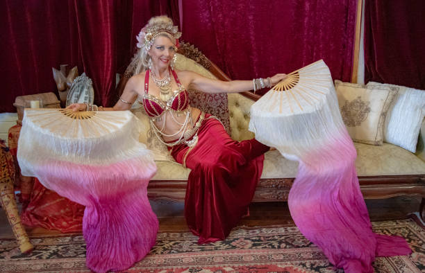 istock Belly dancer rests with silk fans on Chaise Lounge. 1072327730