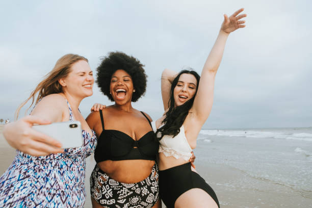 Beautiful curvy women taking a selfie at the beach Beautiful curvy women taking a selfie at the beach black women in bathing suits stock pictures, royalty-free photos & images