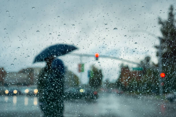 istock Raindrops on the windshield of a car; blurred background 1072338856