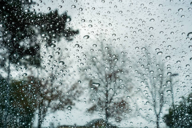 istock Raindrops on the windshield of a car; blurred background 1072340344